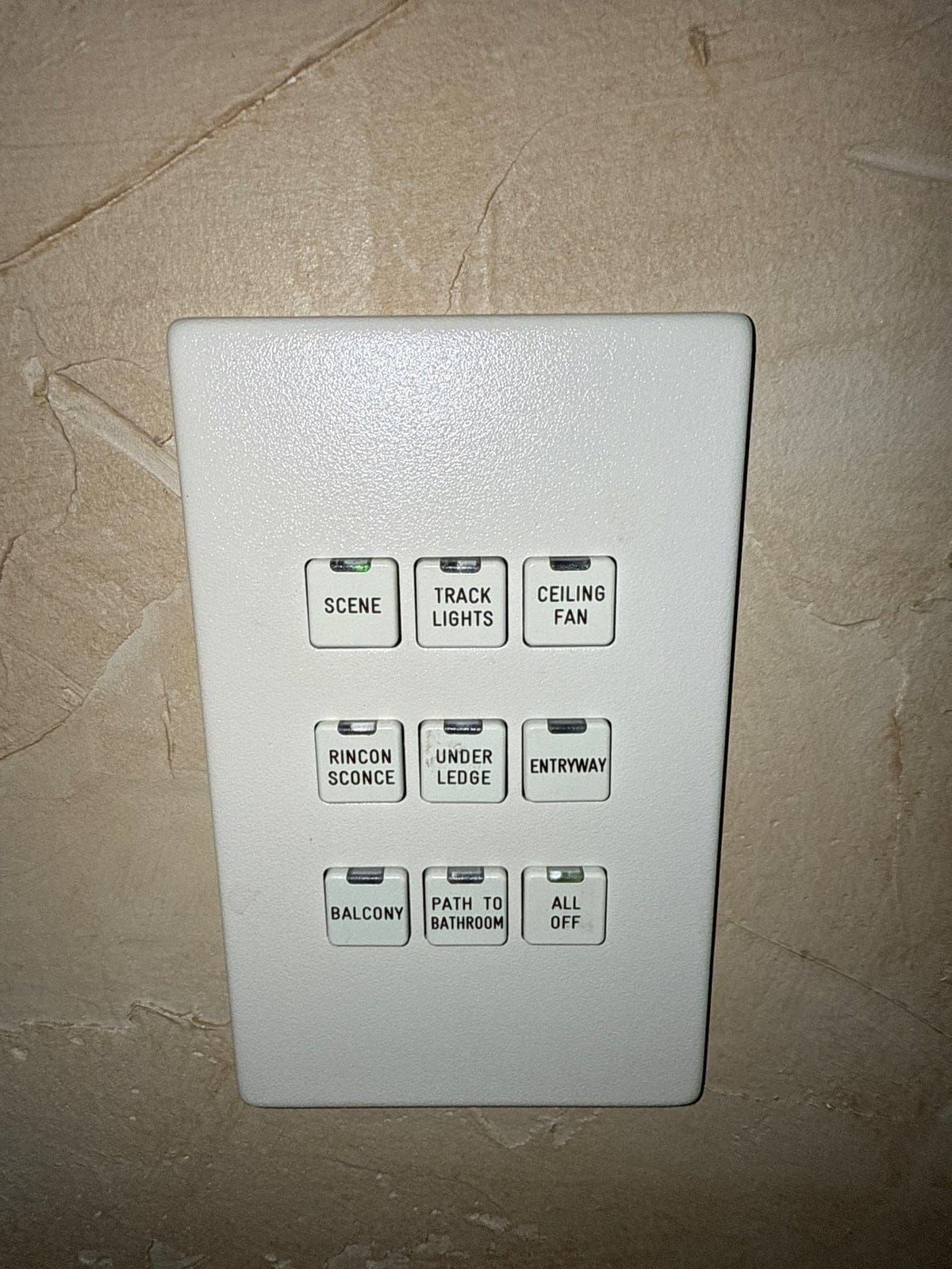 Original LiteTouch lighting keypad mounted in a Houston home — multi-button beige design from the 1990s/2000s
